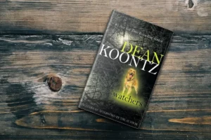 Watchers by Dean Koontz paperback book placed on a wooden table