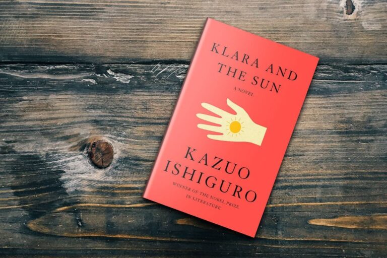 Klara and the Sun by Kazuo Ishiguro lying on a wooden surface, showing the red hardcover design
