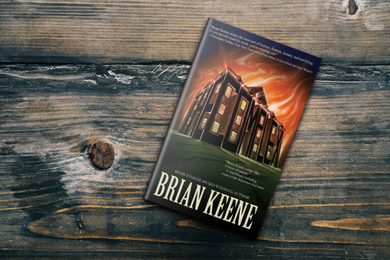 Book The Complex by Brian Keene on a wooden table